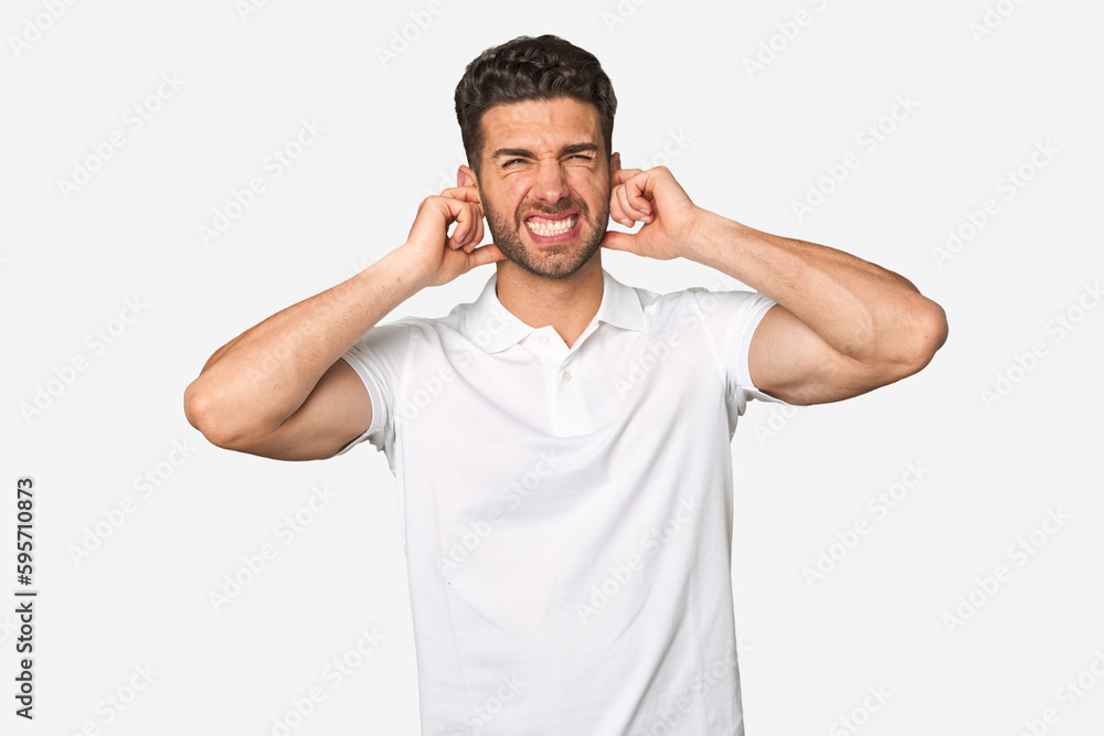 Young handsome man isolated covering ears with hands. Young handsome man isolated covering ears with hands.