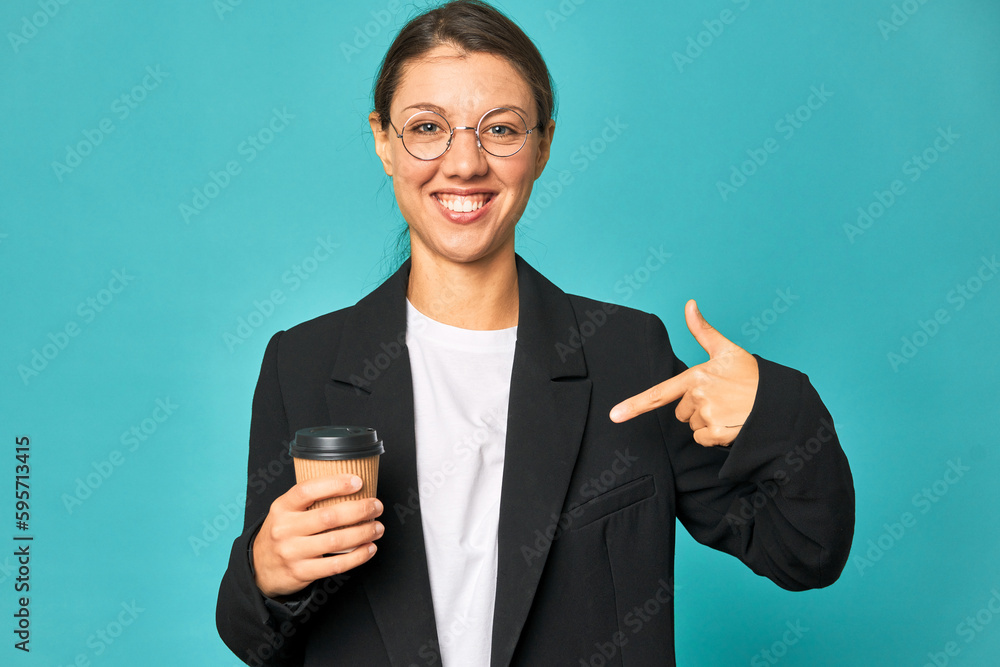 A young caucasian business woman holds a takeaway coffee person pointing by hand to a shirt copy space, proud and confident A young caucasian business woman holds a takeaway coffee person pointing by hand to a shirt copy space, proud and confident