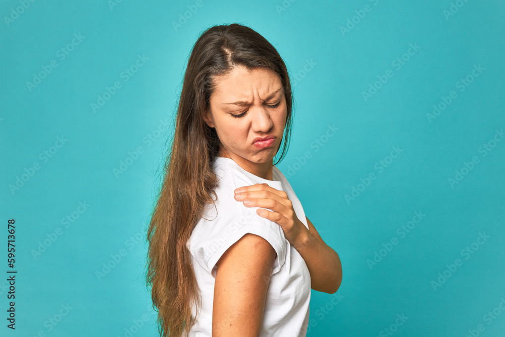 A young caucasian woman isolated having a shoulder pain. A young caucasian woman isolated having a shoulder pain.