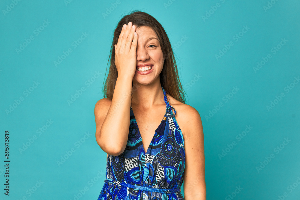A young caucasian woman isolated having fun covering half of face with palm. A young caucasian woman isolated having fun covering half of face with palm.