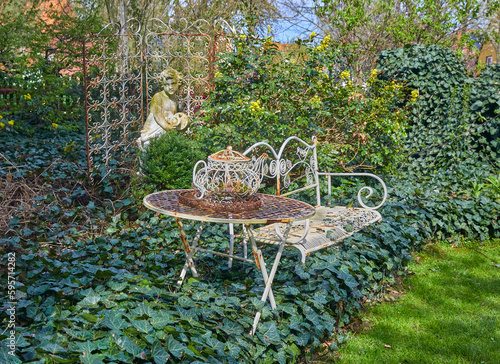 Beautiful old garden furniture with decoration in an idyllic garden.