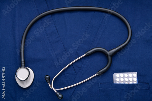 stethoscope with drugs is lying on a blue medical gown.