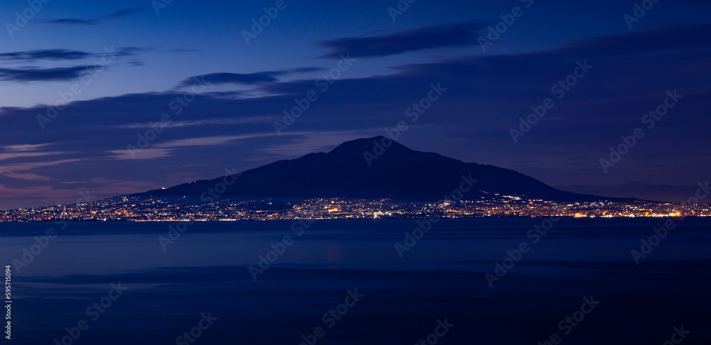 Panorama of Mount Vesuvius at night with city lights of Naples city, Italy