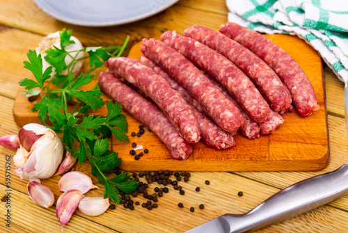 Traditional Catalan raw pork sausage longaniza ready for grilling on wooden board