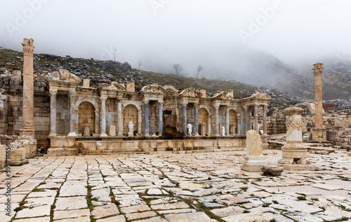 View of ruins of antique Nymphaeum of Sagalassos ancient city, Turkey, in foggy winter day