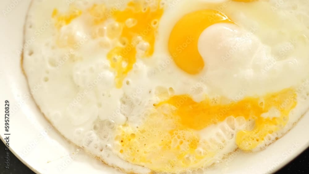 Fried scrambled eggs close-up. View from above. Healthy protein breakfast.Appetizing fried eggs in sunflower oil. High quality 4k footage Fried scrambled eggs close-up. View from above. Healthy protein breakfast.Appetizing fried eggs in sunflower oil. High quality 4k footage