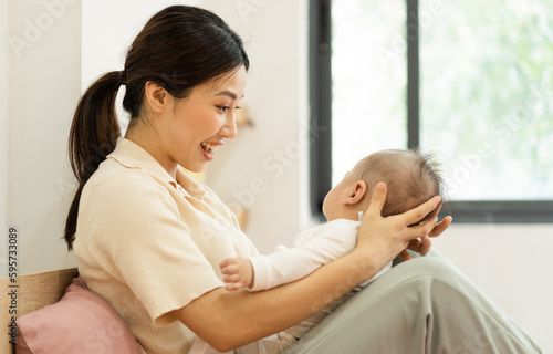 Asian mother and newborn baby feet are smiling and happy