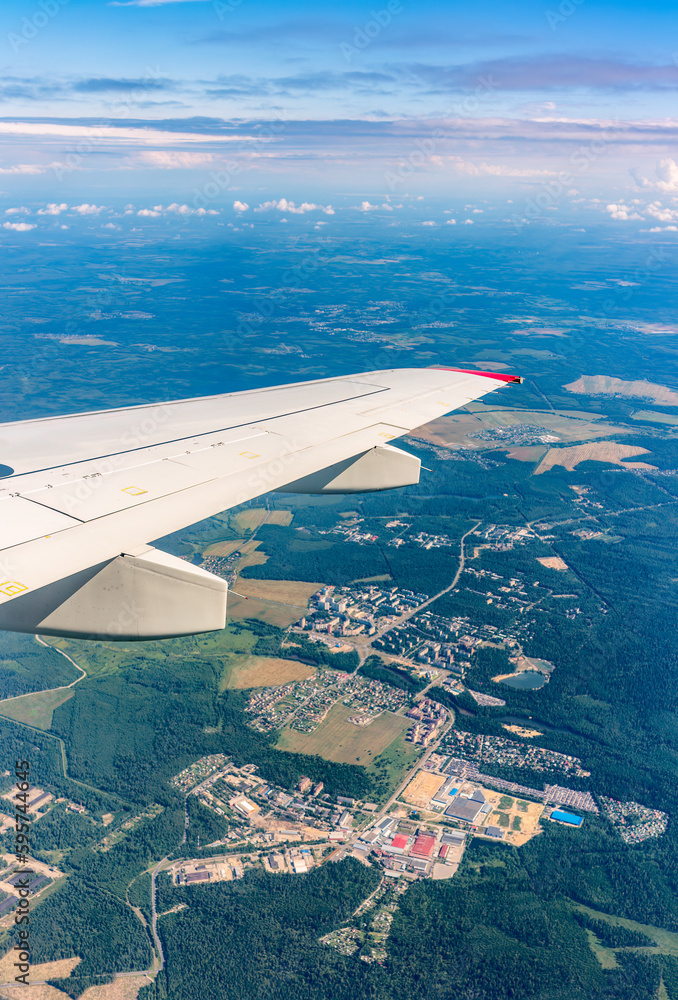 Obraz premium View from the airplane window at a beautiful cloudy sky and the airplane wing