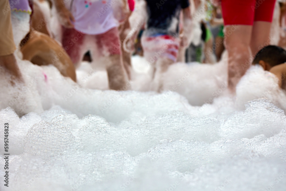 Foamy entertainment party, people are merrily floundering in the foam, catching soap bubbles. Cheerful people have fun at the holiday with soap bubbles Foamy entertainment party, people are merrily floundering in the foam, catching soap bubbles. Cheerful people have fun at the holiday with soap bubbles