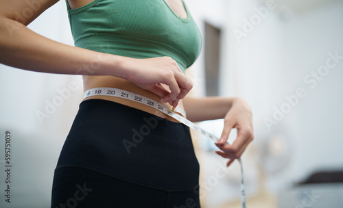 Asian woman with anorexia  with measuring tape feeling unhappy. Anorexia problem body perception and dysmorphia concept