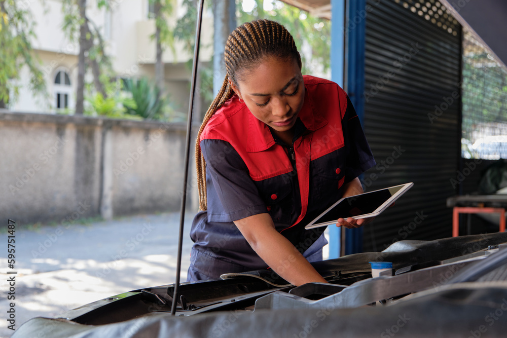 One Black female professional automotive mechanical worker checks an EV