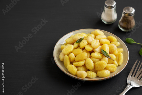 Homemade Easy Potato Gnocchi on a Plate on a black background, side view. Copy space.