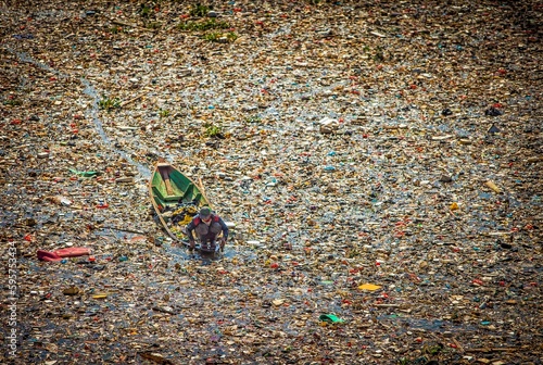 Vászonkép People collect trash that can be recycled and traded from the sea of garbage in the Citarum River, Bandung, Wes Java