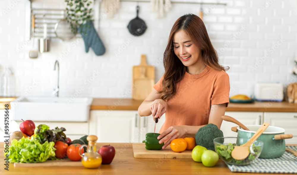 Portrait of beauty body slim healthy asian woman having fun cooking and preparing cooking vegan food healthy eat with fresh vegetable salad on counter in kitchen at home.Diet concept.healthy food
