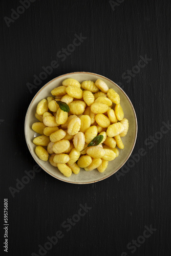 Homemade Easy Potato Gnocchi on a Plate on a black background, top view. Flat lay, overhead, from above.