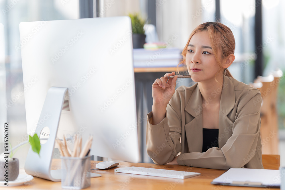 Obraz premium appy young businesswoman Asian siting on the chairs cheerful demeanor raise holding coffee cup smiling looking laptop screen .Making opportunities female working successful in the office.