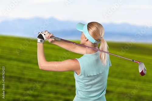 Young woman golfing on the green course in summer