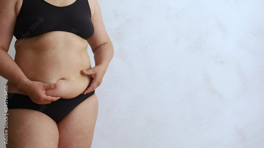 Unrecognizable black woman in underwear showing excessive fat on