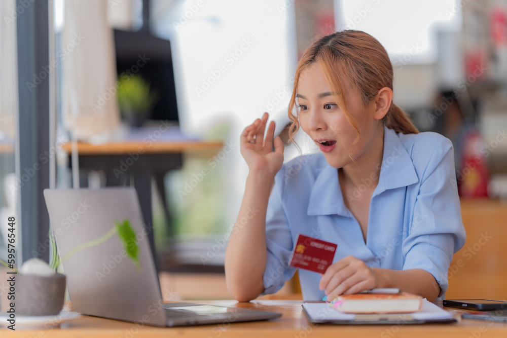 Asian woman using credit card shopping online at the office