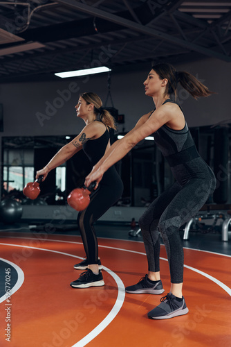 Sporty women doing russian kettlebell exercise in a gym.