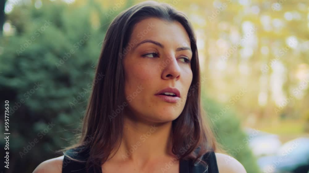 A young woman smiles and breathes deeply in a black tank top takes time to reflect on her rigorous cardio workout to keep herself and her heart in good shape and peak physical condition. A young woman smiles and breathes deeply in a black tank top takes time to reflect on her rigorous cardio workout to keep herself and her heart in good shape and peak physical condition.