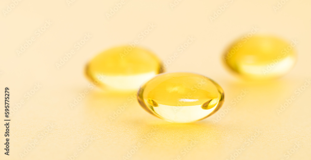 Fish oil supplement capsules on gold background. Cosmetics, omega 3 golden bubble. Gold oil capsules. Vitamin round pill set. Fish oil supplement capsules on gold background. Cosmetics, omega 3 golden bubble. Gold oil capsules. Vitamin round pill set.