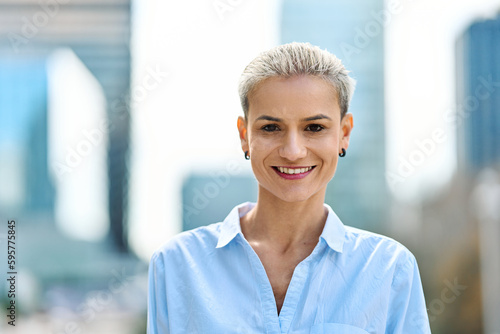 Smiling businesswoman looking at camera standing outdoors