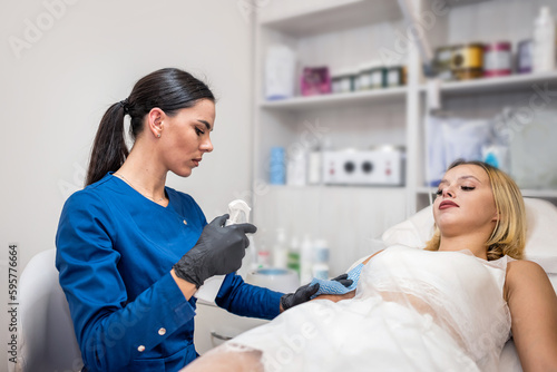 Wallpaper Mural Beautican making waxing hair removal procedure on hand for woman client Torontodigital.ca