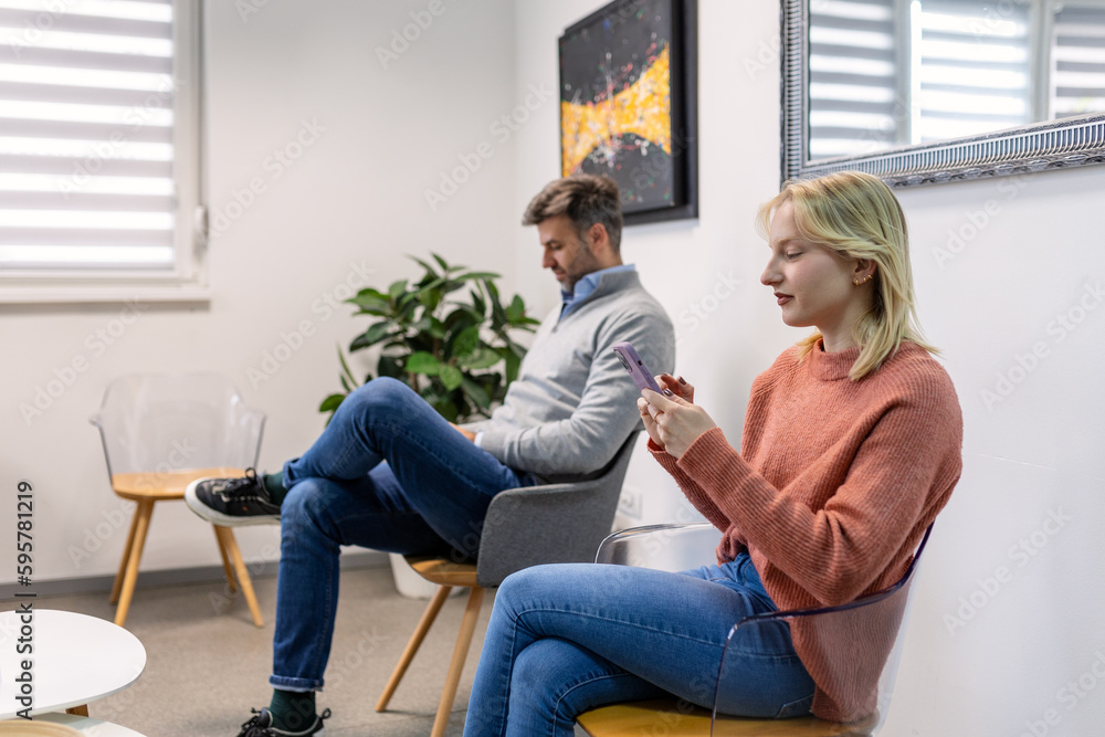 People, man and woman sitting in a queue, and waiting for a doctor's appointment in the hospital. Waiting room concept. People, man and woman sitting in a queue, and waiting for a doctor's appointment in the hospital. Waiting room concept.