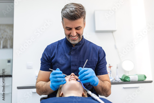 Attractive young woman in stomatology clinic with male dentist. Healthy teeth concept.