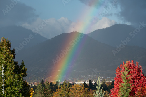 Rainbow over a small town in the mountains on a stormy day