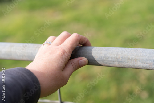 Hand on metal farm fence © Em Neems Photography