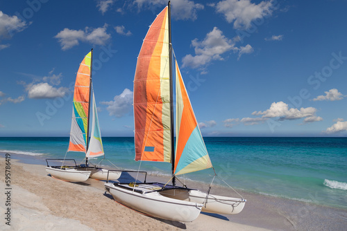Colorful sailing catamaran on the beach of the Varadero -  Cuba.
Turquoise blue Atlantic water and blue sky with white clouds.