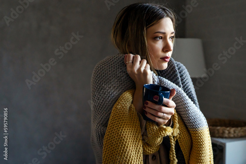 Fotografia Freezing woman suffering from cold or flu fever or having trouble with central h