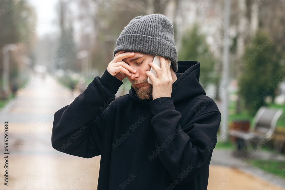 Man talking on the phone and holding his head, bad news. Man talking on the phone and holding his head, bad news.
