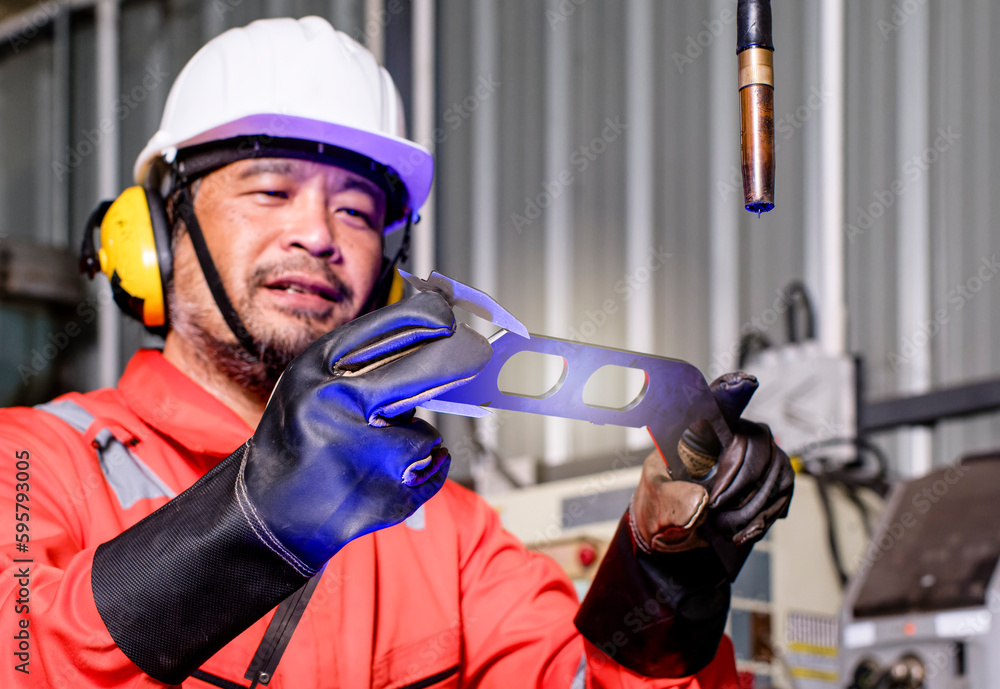 Male automation engineer checking and inspection control a robot arm welding .machine with tablet in an industrial factory. .Artificial intelligence concept. Male automation engineer checking and inspection control a robot arm welding .machine with tablet in an industrial factory. .Artificial intelligence concept.
