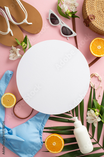 Stylish creative vacation concept. Top view of flip-flops, bikini vintage sunglasses, bag, and green palm leaves flowers on a pastel pink background with an empty circle for text or advert.