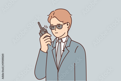 Man bodyguard use walkie-talkie to inform security service about arrival guest