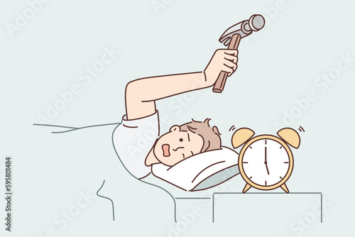 Annoyed man hits alarm clock with hammer not wanting to wake up on day off and go to unloved job
