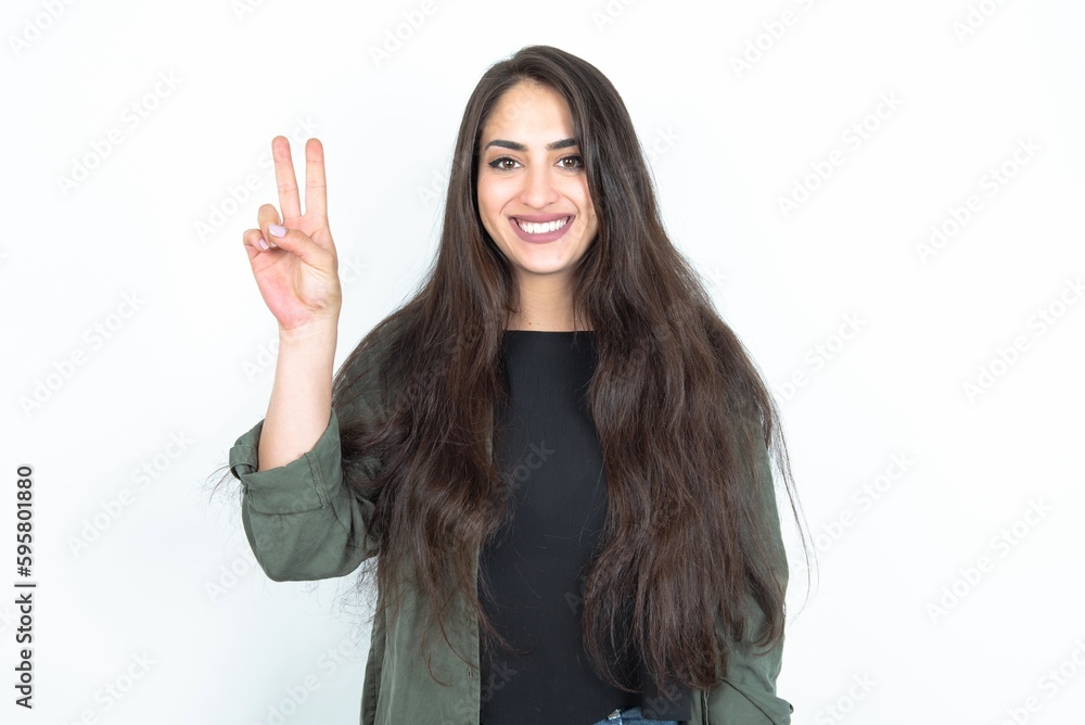 young brunette woman wearing casual clothes over white studio background showing and pointing up with fingers number two while smiling confident and happy. young brunette woman wearing casual clothes over white studio background showing and pointing up with fingers number two while smiling confident and happy.