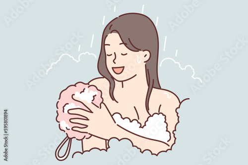 Woman takes shower using washcloth and stands among foam enjoying hygiene procedures