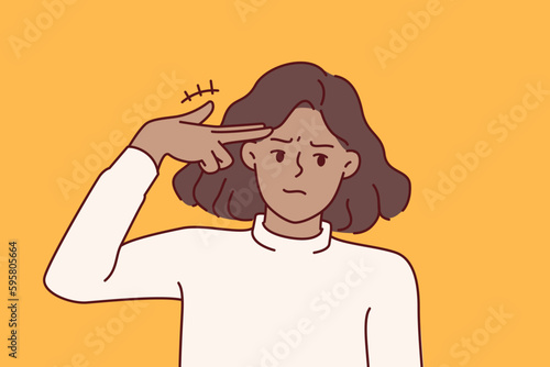 Woman with smirk makes pistol gesture, putting fingers to temple for metaphor for suicide associated with problems in personal life. Young girl wishes to commit suicide after relationship problems