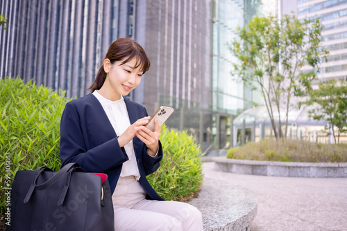 スマホを触る日本人ビジネスウーマン