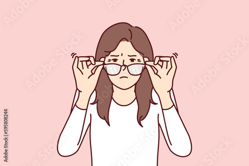 Woman with vision problems squint when touching does not help them see fine print at distance. Young girl loses vision and needs help of ophthalmologist or vitamin with beneficial substances for eyes photo