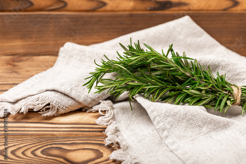 Branches of fresh rosemary on a brown texture background. Spicy spices. Seasoning for meat and fish. Cooking concept. RECEPT. Close-up. place for text. photo