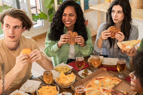 multiracial friends eating burgers at home  millennials meeting in apartment