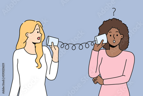 Diverse women talk with tin can telephone have misunderstanding. Multiracial friends speak on handmade can phone having problems communicating. Vector illustration. 
