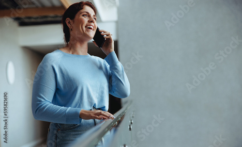 Business communications: Professional woman answering a phone call in an office photo