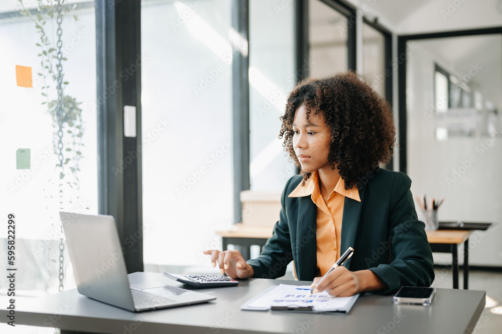 Confident business expert attractive smiling young woman typing laptop ang holding digital tablet on desk in office. Confident business expert attractive smiling young woman typing laptop ang holding digital tablet on desk in office.
