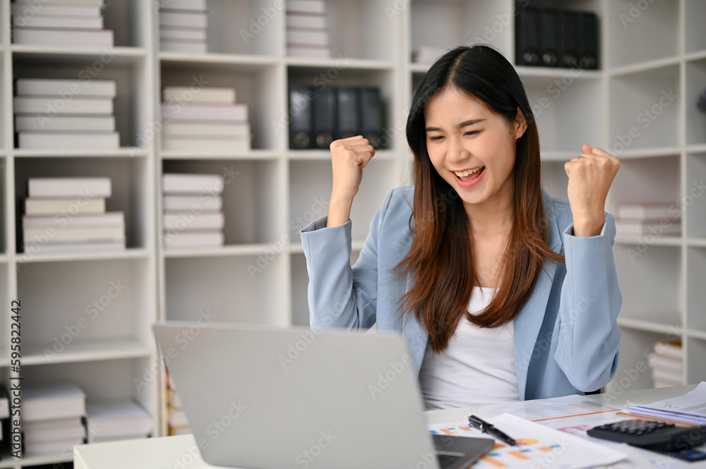 Excited Asian businesswoman celebrating and rejoicing her career success